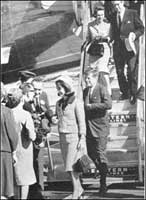 Mrs. Kennedy is presented with a bouquet of blood RED roses. 