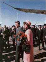 Mrs. Kennedy holding her bouquet of RED roses. 